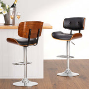 Artiss 4x Bar Stools with wooden structure, black PU leather padded seat, and chrome base in a modern kitchen setting.