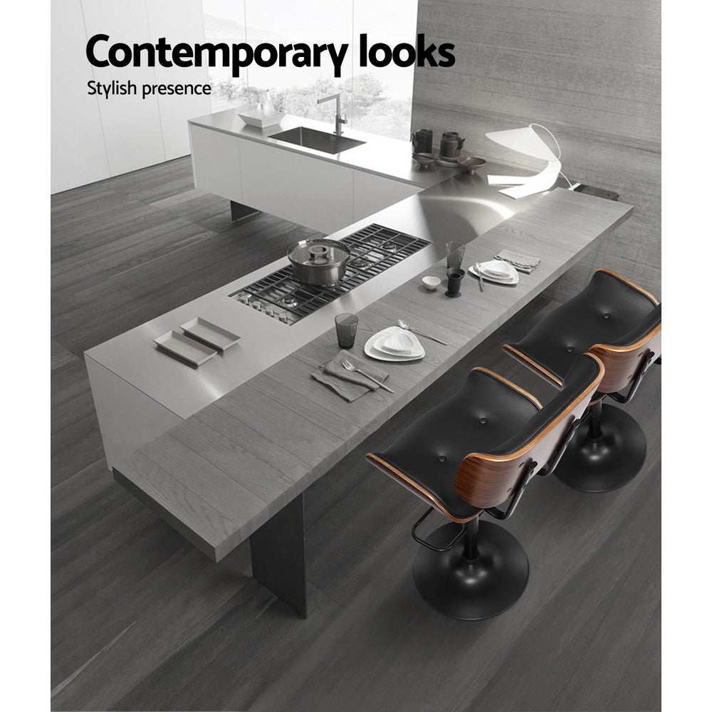 Artiss 4x Bar Stools with black leather seats and chrome bases at a modern kitchen island.