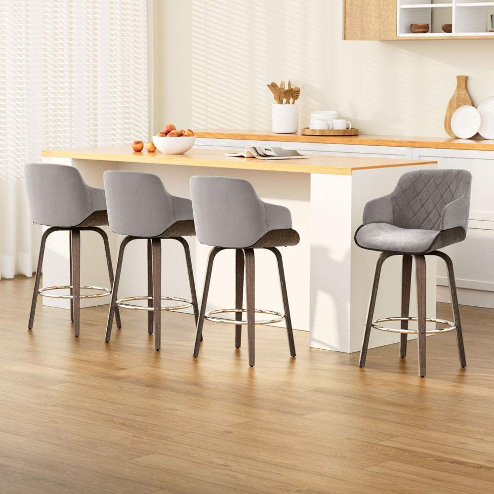4x swivel velvet bar stools with wooden legs and chrome footrest.