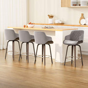 4x swivel velvet bar stools with wooden legs and chrome footrest.