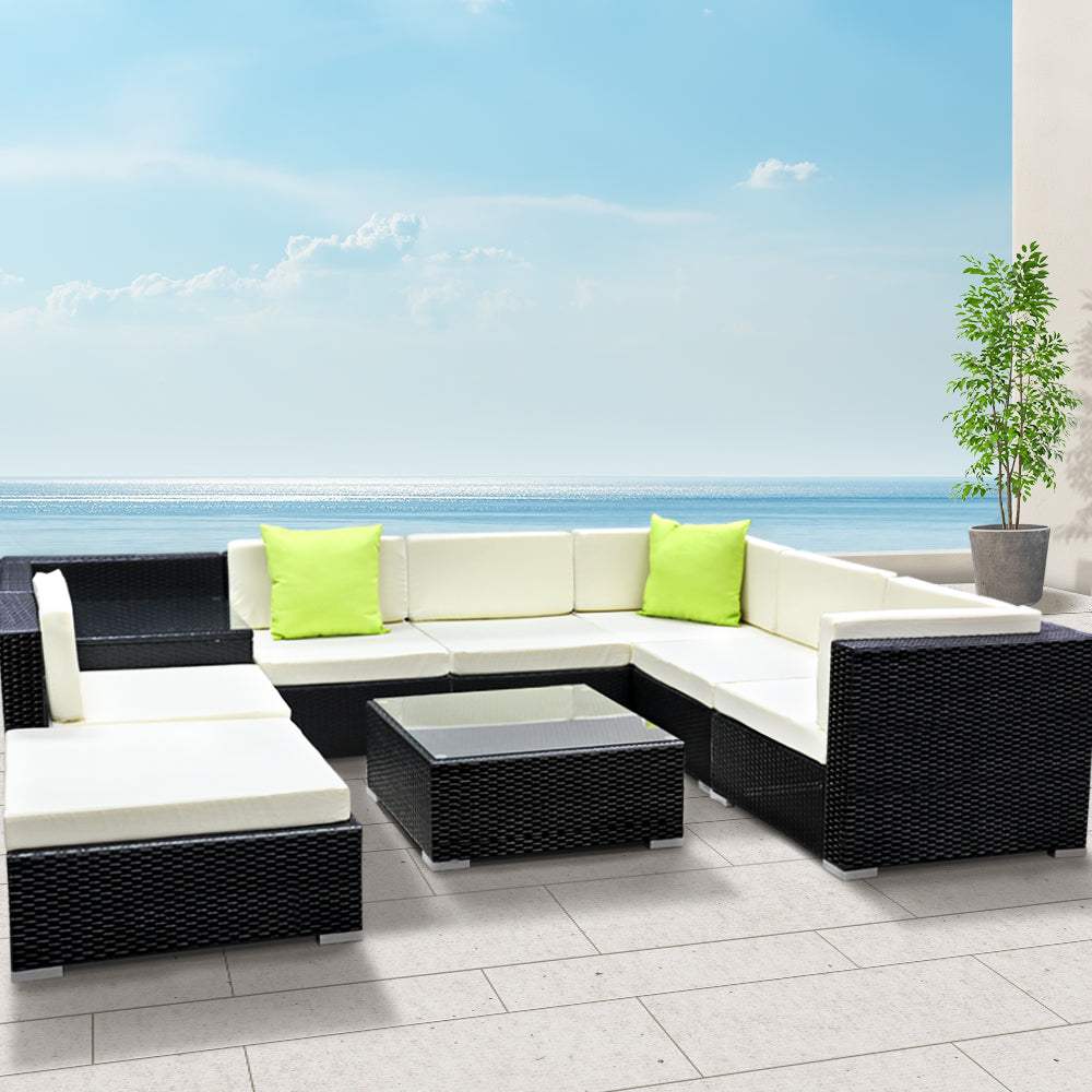 Gardeon 9-piece outdoor furniture set with wicker couches, beige cushions, black aluminum frame, lime green throw pillows, and glass top tables.