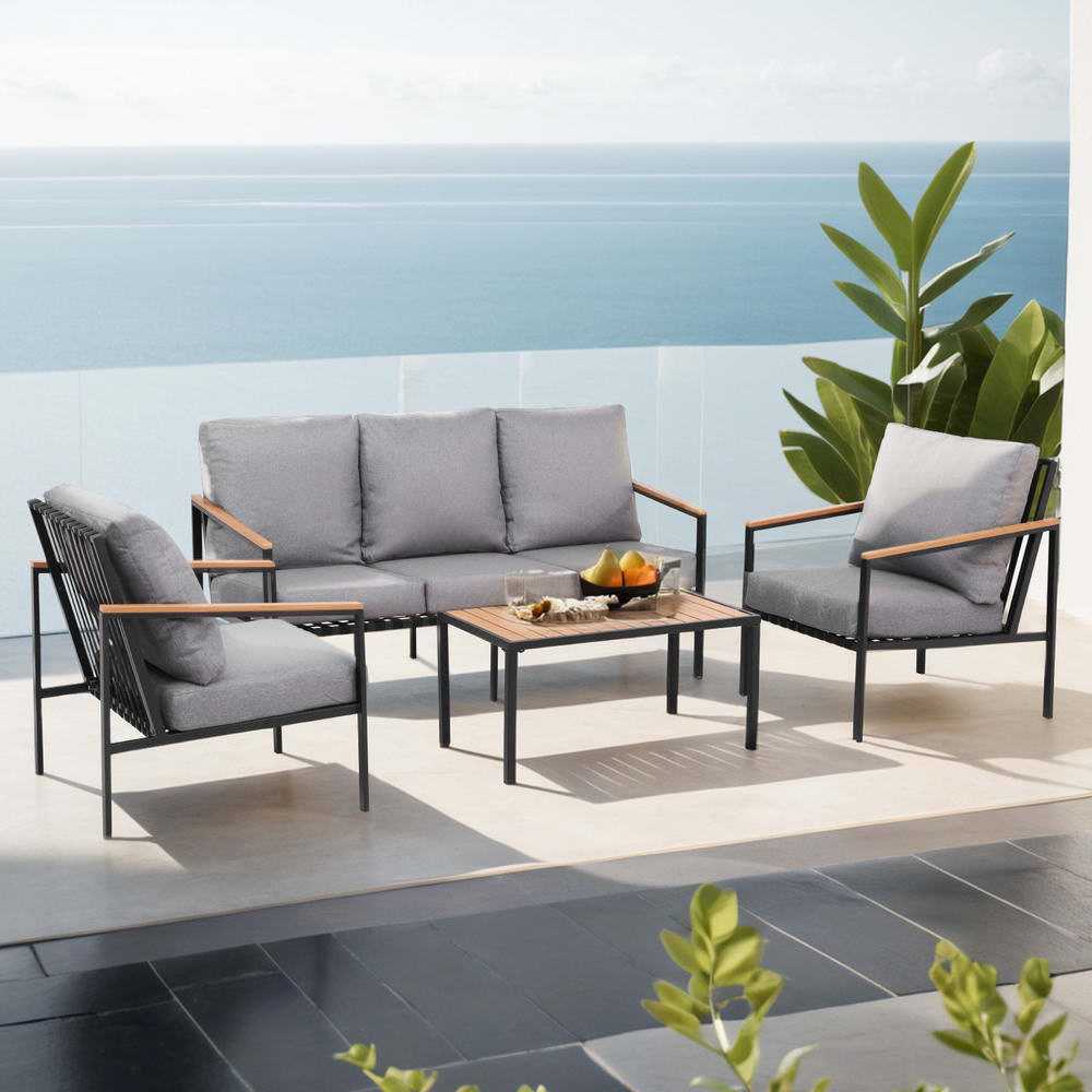 Gardeon 5 seater outdoor sofa set on patio with ocean view, featuring grey cushions and a center table.
