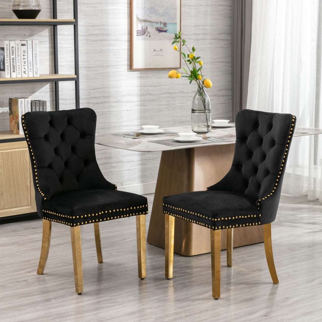 4x black velvet dining chairs with golden metal legs and button-tufted backrest.