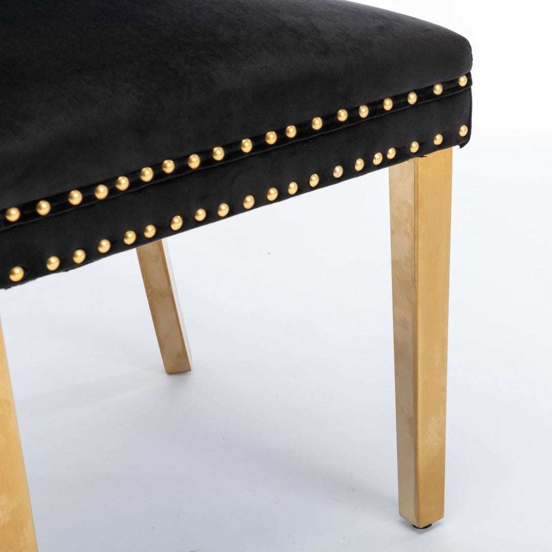Black velvet dining chair with golden metal legs and decorative studs.