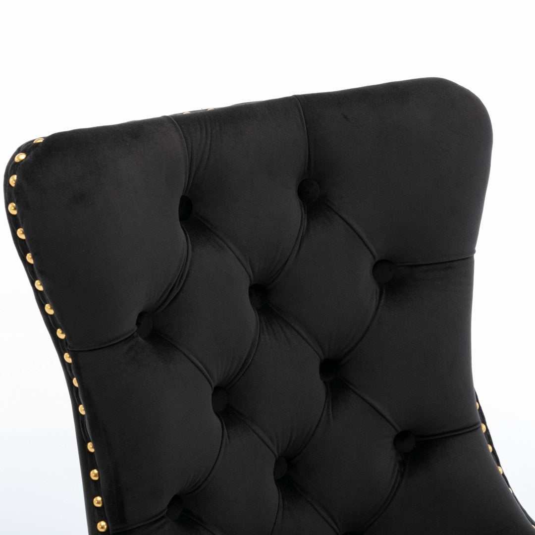 Black velvet dining chair with button-tufted backrest and gold metal legs.