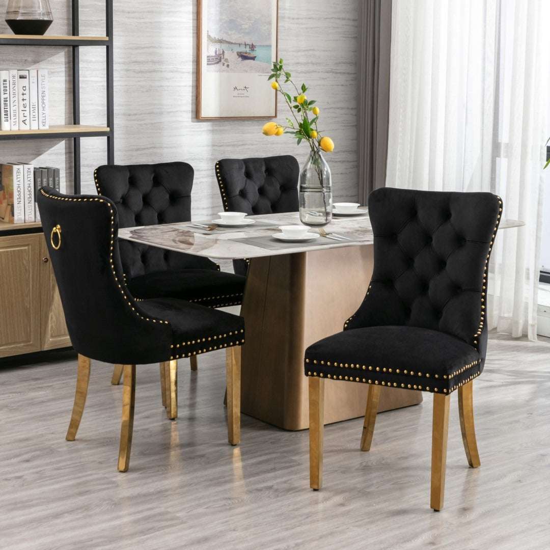 4x black velvet dining chairs with golden metal legs and button-tufted backrest.