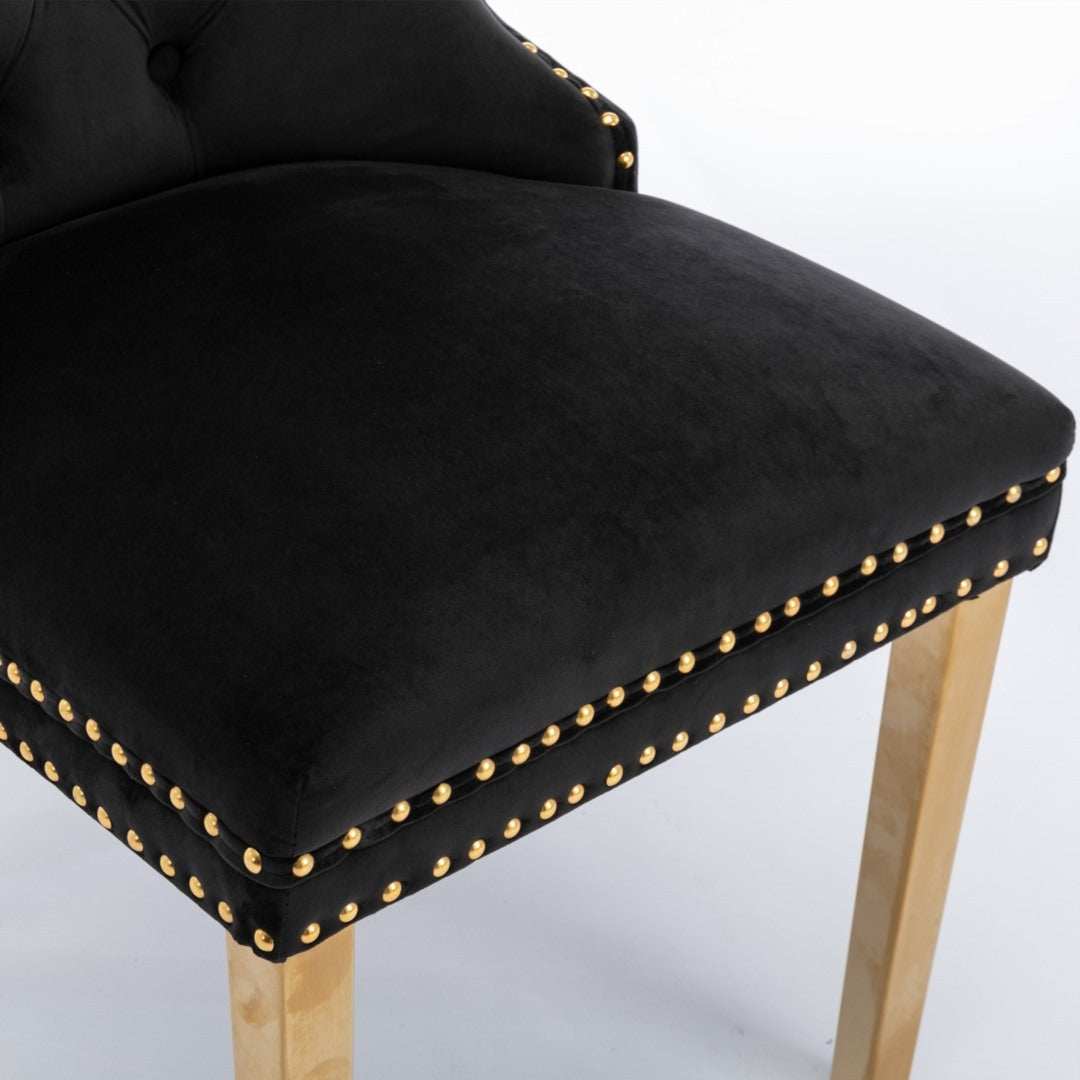 Black velvet dining chair with golden metal legs and decorative gold studs.