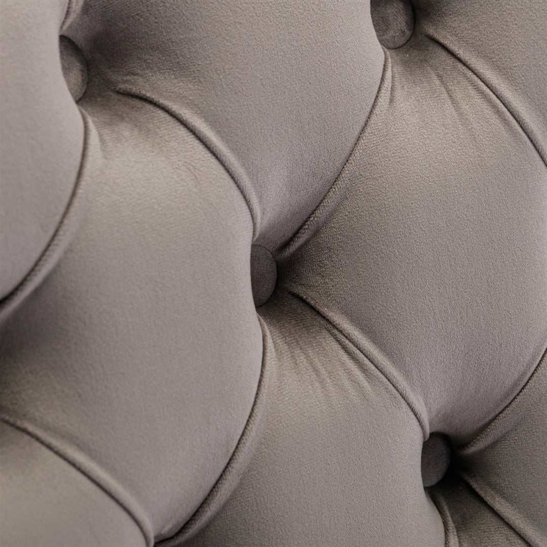 Velvet dining chairs with button-tufted design and grey upholstery.