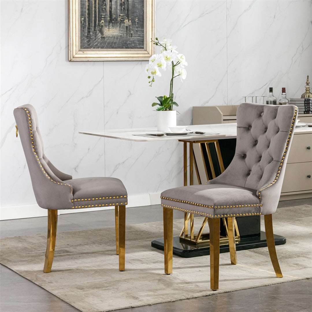 Grey velvet dining chairs with button-tufted back and golden metal legs in elegant dining setting.