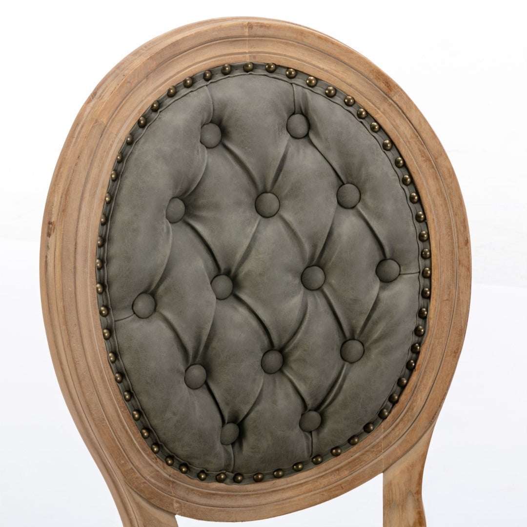 Velvet faux leather dining chair with solid wood frame, hand-tufted back, and nailhead trim detail.
