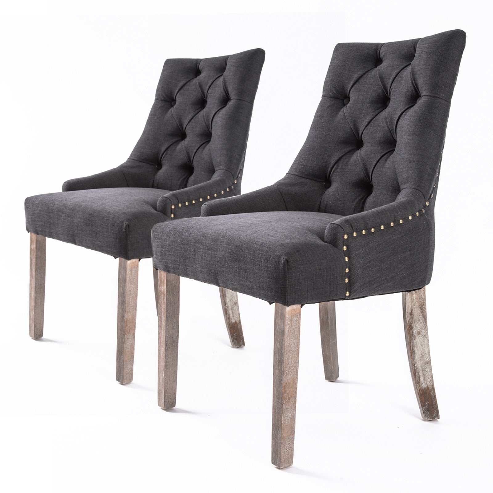 Set of 2 black French Provincial dining chairs with deep tufting, brass studs, and oak legs.