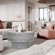 Black diamond-patterned mother of pearl coffee table with seashell embellishments in elegant living room setting.